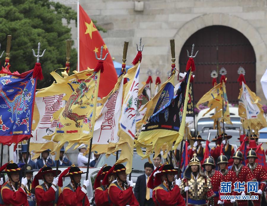 7月3日，韓國總統(tǒng)樸槿惠在青瓦臺總統(tǒng)府舉行隆重儀式，歡迎中國國家主席習(xí)近平對韓國進(jìn)行國事訪問。這是習(xí)近平的車隊在身著民族服裝的韓國禮儀隊伍引導(dǎo)下駛?cè)肭嗤吲_。新華社記者丁林?jǐn)z  